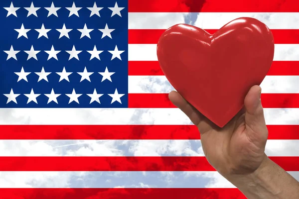 Rood hart in een man's hand mooie Amerikaanse nationale vlag op delicate zijde met zachte plooien, close-up, kopieer ruimte Stockafbeelding