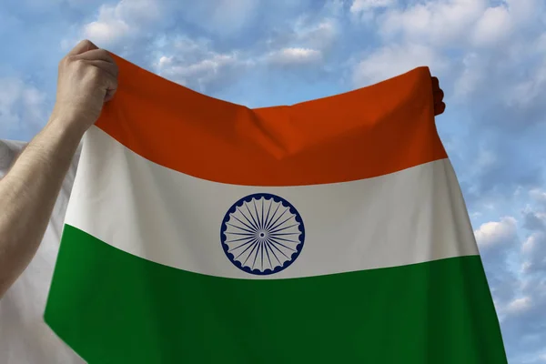 Indah bendera nasional India negara di tangan laki-laki terhadap langit biru dengan awan — Stok Foto