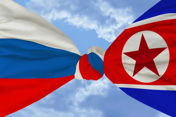 national flag of Russia is firmly tied to a knot with the national flag of North Korea against the blue sky with clouds, the concept of friendship, cooperation, unity, international union