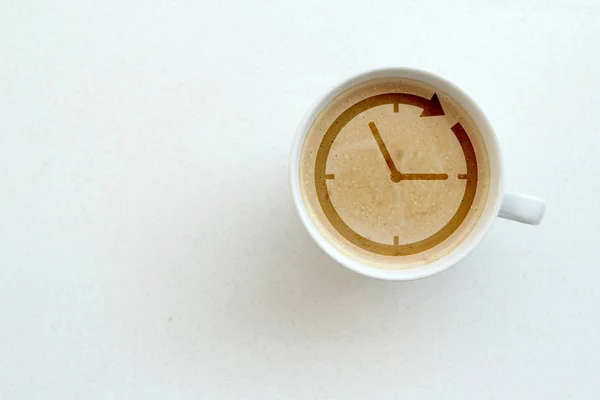 Taza de café blanco ancho, capuchino con leche, cacao con un patrón de reloj en una mesa blanca, vista superior, ahorrar espacio, primer plano, concepto de tiempo — Foto de Stock