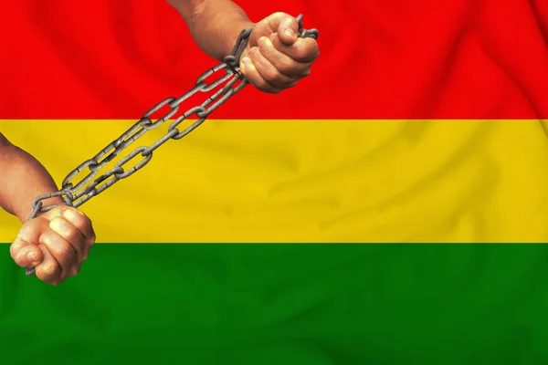 male hands chained in heavy iron chains against the background of the flag of the State of Bolivia silk, the concept of the movement in support of human rights