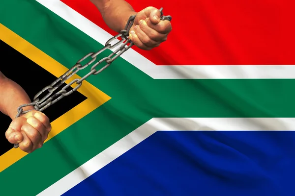 Mani maschili incatenate in pesanti catene di ferro sullo sfondo della bandiera del Sud Africa su una seta delicata con pieghe nel vento, il concetto del movimento a sostegno dei diritti umani — Foto Stock