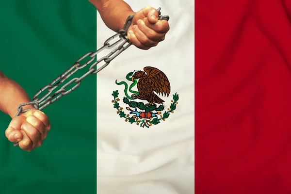 Male hands chained in heavy iron chains against the background of the flag of Mexico on a gentle silk with folds in the wind, the concept of movement in support of human rights — Stock Photo, Image