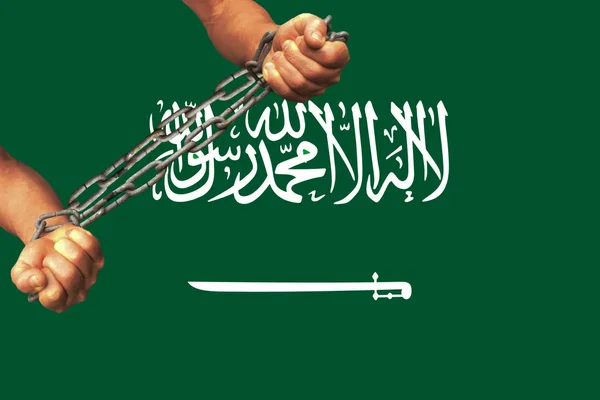 Manos de hombres encadenadas en pesadas cadenas de hierro sobre el fondo de la bandera de Arabia Saudita sobre suave seda con pliegues en el viento, el concepto de un movimiento en apoyo de los derechos humanos — Foto de Stock