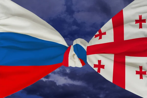 The national flag of Russia is closely linked with the national flag of Georgia against the backdrop of a stormy sky with clouds, the concept of hostility and conflict