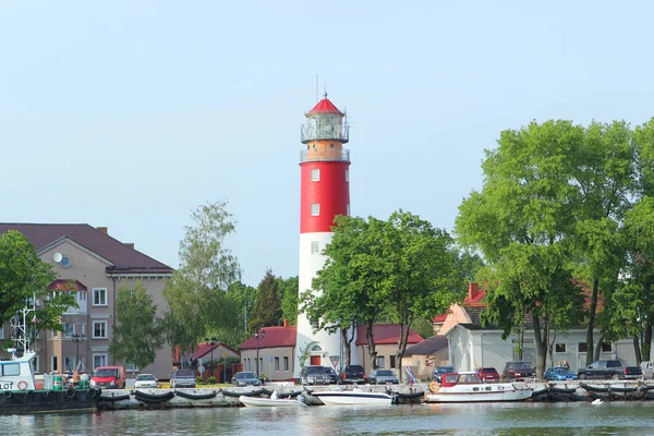 Baltiysk, russland, Mai 2016: die Ostseeküste in der Stadt Baltiysk mit einem schönen alten Leuchtturm und Schiffen am Pier — Stockfoto