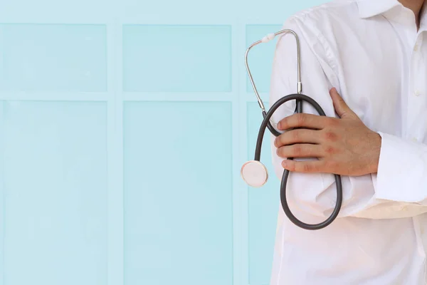 Doktor elinde modern bir klinik, yakın çekim, kavram mavi bir arka plan üzerinde bir stetoskop tutar — Stok fotoğraf