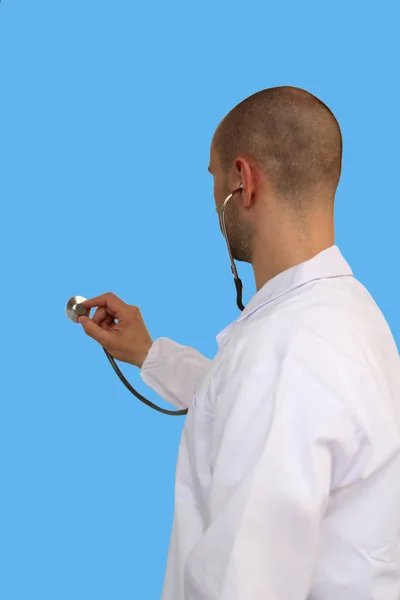 Médecin écoute avec un phonendoscope, vue arrière sur un fond bleu isolé, gros plan, concept, isoler — Photo