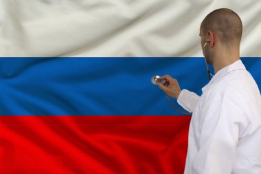 beyaz ceketli erkek doktor ulusal bayrak, arka görünüm, kavram, kopya alanı bir stetoskop ile tıbbi bir alet uygulanan