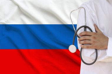 elinde beyaz ceketli erkek doktor ulusal bayrak, yakın çekim, konsept, fotokopi alanı arka plan karşı bir stetoskop ile tıbbi bir alet tutarak