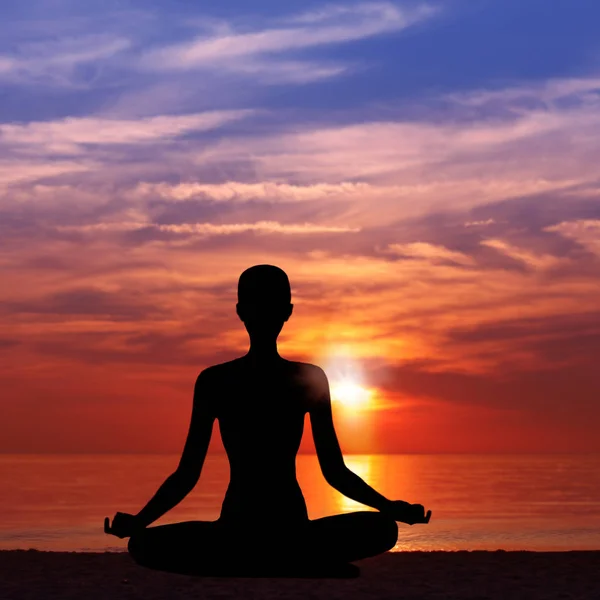 Silhouette of Woman Meditating in Lotus Position by the Sea at Sunset. Nature Meditation Concept. Low key photo. relax time Stock Image