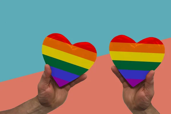 Dos arco iris gay orgullo símbolo corazón en forma de manos en el fondo geométrico en vibrante coral, turquesa, espacio de copia —  Fotos de Stock