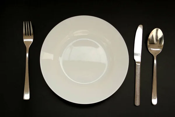 Cubertería junto a un plato blanco vacío, espacio para copiar — Foto de Stock