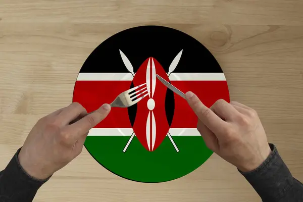 Mani con posate su un piatto con la bandiera nazionale dello stato del Kenya, copiare lo spazio — Foto Stock