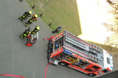 parlak sarı üniformalı itfaiyeciler ekibi Almanca frankfurt İtfaiye bir yazıt ile parlak kırmızı servis itfaiye aracı yakınında duruyor