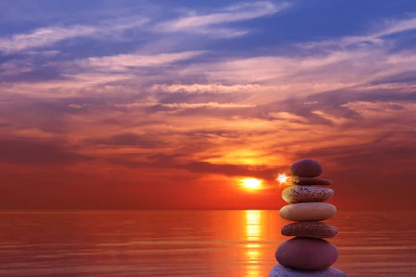 Pyramids of stones in the sand symbolizing Zen, harmony, balance. ocean at sunset in the background — Stock Photo, Image