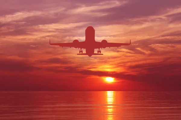 Silhouette of plane in the sky above Sea at Sunset. travel, flight, vacation Concept. Low key photo. relax time — Stock Photo, Image