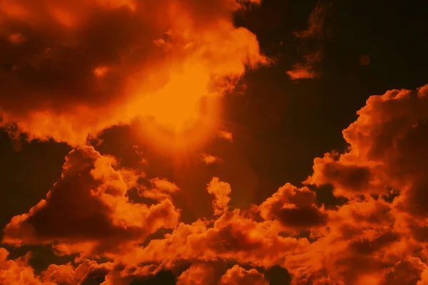 Fotografía naranja teñida del cielo con nubes y sol con reflejos, el concepto del calor del verano, la preparación para el diseñador, primer plano —  Fotos de Stock