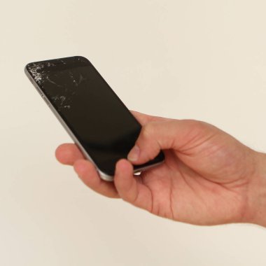 erkek elinde siyah kırık ekran ile cep telefonu, kare
