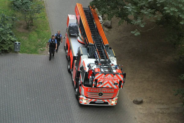 Франкфурт, Германия, июнь 2019: двое полицейских, мужчина и женщина, пришли на вызов, прошли по ярко-красной пожарной машине — стоковое фото
