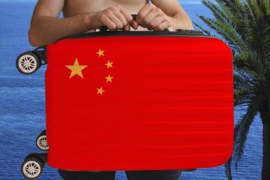tourist holds with two hands a suitcase with the national flag of China, a symbol of tourism, immigration, political asylum clipart
