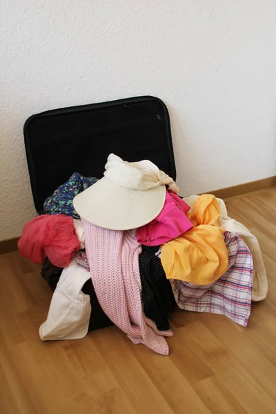 Abierto y lleno de cosas maleta, un símbolo de vacaciones, viajes por el mundo, turismo, inmigración, asilo político — Foto de Stock