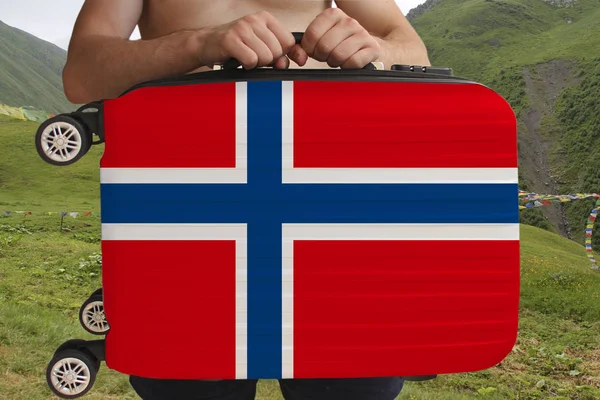Tourist houdt met twee handen een koffer met de nationale vlag van Noorwegen, een symbool van het toerisme, immigratie, politiek asiel — Stockfoto