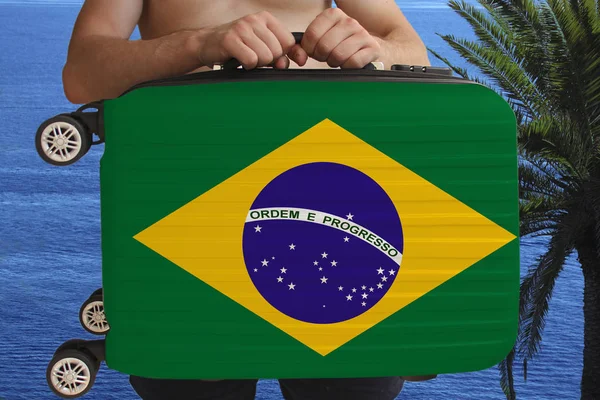 Tourist holds with two hands a suitcase with the national flag of Brazil, a symbol of vacation, immigration — Stock Photo, Image