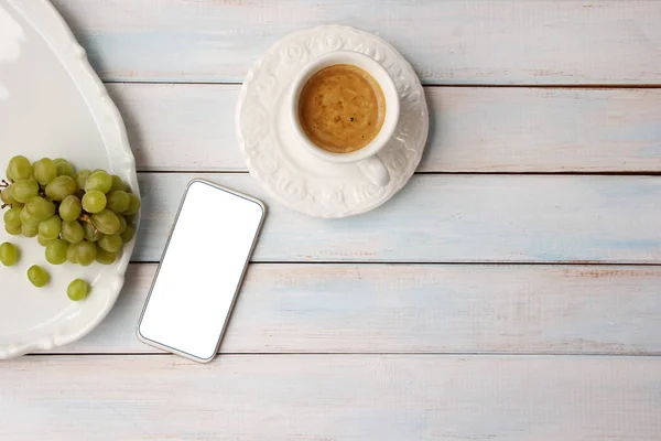스마트 폰의 텍스트에 대한 흰색 공백과 커피가있는 흰색 컵, 접시에 포도, 개념 아침, 상단보기, 복사 공간 — 스톡 사진