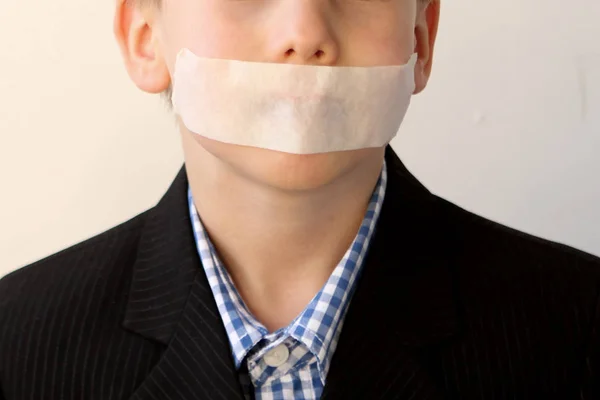 Deels het gezicht van een jongen in een zwart pak met de mond vast, het concept van huiselijk geweld — Stockfoto