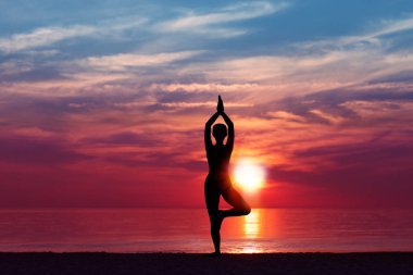 Yoga Meditasyon Kadın Siluet Gün batımında Deniz tarafından poz. Doğa Meditasyon Kavramı. Düşük anahtar fotoğrafı. dinlenme zamanı