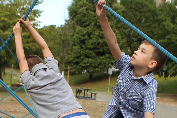 두 소년은 공원에서 놀이터에 거리 스포츠 장비를 등반 — 스톡 사진