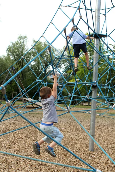 Zwei Jungen klettern auf Straßensportgeräte auf Spielplatz im Park — Stockfoto