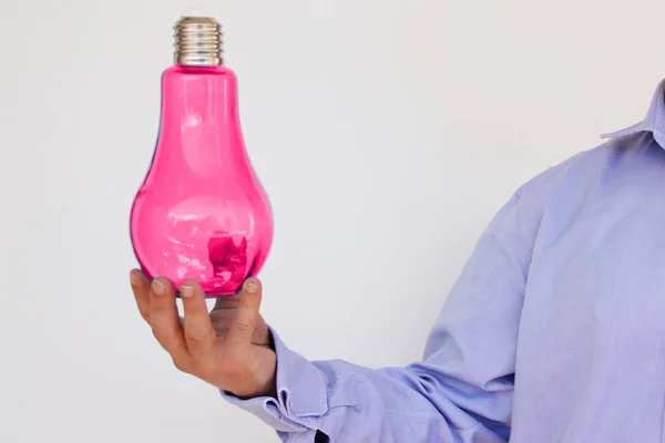 Homme d'affaires en chemise bleue tient dans sa main une grande lampe en verre rose, concept électrique, idée, espace de copie — Photo