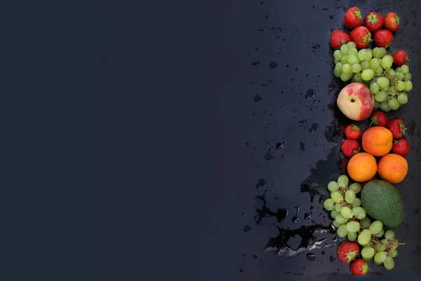 新鮮なジューシーなイチゴ、ブドウ、桃、アプリコット、水の水の滴で黒い濡れた背景にアボカド、トップビュー — ストック写真