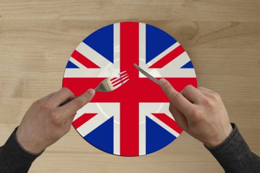 Büyük Britanya ulusal bayrağı ile bir tabak üzerinde çatal ile eller, kopya alanı