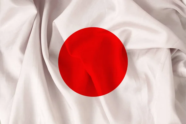 Beautiful national flag of Japan on soft silk with soft folds, close-up, top view, copy space — Stock Photo, Image