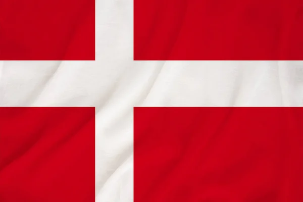 The national flag of the country of Denmark on the gentle silk with folds from the wind, the concept of travel, immigration, politics, copy space, close-up — Stock Photo, Image