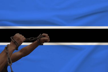 devlet bayrağının arka planına karşı kalın bir demir çar sarılmış kaslı erkek elleri, siyasi mücadele kavramı, suç, zulüm, hapis, insan özgürlüğünün ihlali