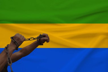 devlet bayrağının arka planına karşı kalın bir demir çar sarılmış kaslı erkek elleri, siyasi mücadele kavramı, suç, zulüm, hapis, insan özgürlüğünün ihlali