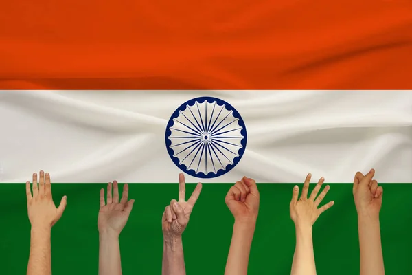 De nombreuses mains levées des gens sur le fond d'un drapeau d'État en soie de couleur avec des plis doux, concept d'unité du peuple — Photo