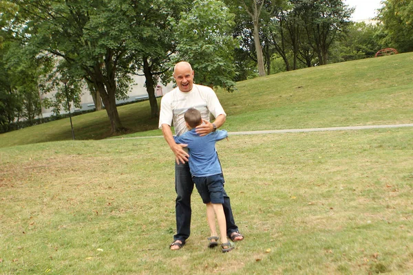 Niño, preescolar, estudiante de primaria están solos con un hombre mayor, abrazando, en el parque, concepto de relaciones familiares — Foto de Stock