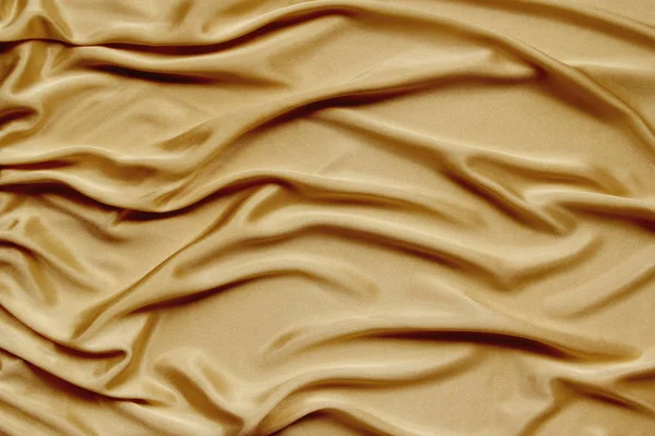 Arany gyönyörű szatén szövet draped puha redők, selyem ruhával háttér, közeli, másolási tér — Stock Fotó