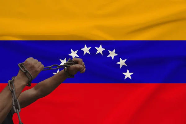 muscular male hands wrapped in a thick iron czar against the background of the state flag, the concept of political struggle, crime, cruelty, imprisonment, violation of human freedom