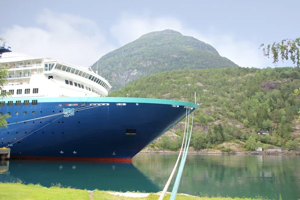Hillesult, Noorwegen-juli 2019: multi-tiered Blue cruiseschip van het Spaanse bedrijf Pullmantur Cruises staat aan de pier in de prachtige Scandinavische fjord van Noorwegen tussen de hoge bergen, dichtbij- — Stockfoto