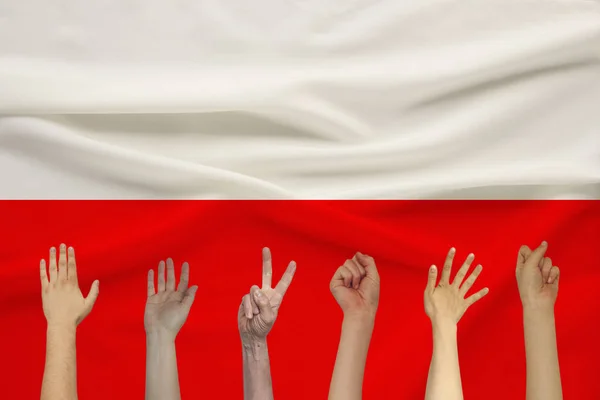 Mange hævede hænder af mennesker på baggrund af en farvet silke stat flag med bløde folder, folk enhed koncept - Stock-foto