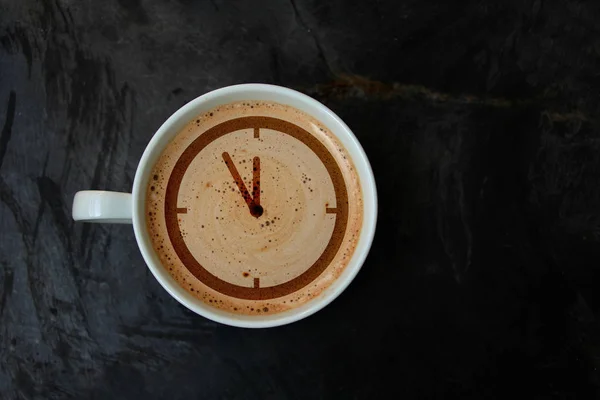 Tazza bianca con cappuccino e schiuma sotto forma di un quadrante dell'orologio modello, vista dall'alto, primo piano, spazio copia — Foto Stock