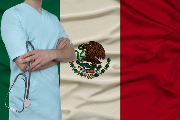 male doctor in uniform professional clothes with a stethoscope stands against the background of the national flag, the concept of the country's health and medical insurance, close-up, copy space