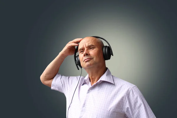 Älterer Mann in schwarzen Kopfhörern mit Emotionen im Gesicht gestikuliert, isoliert, fotografiert, Konzept, Nahaufnahme, Kopierraum — Stockfoto