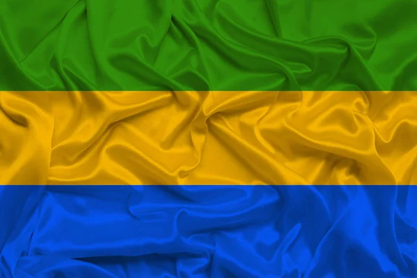 Beautiful photo of the national flag of Gabon on delicate shiny silk with soft draperies, the concept of state power, country life, horizontal, close-up, copy space — Stock Photo, Image